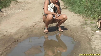 Блондинка присела поссать у лужи